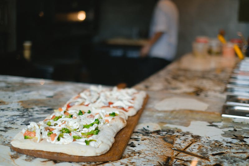 Fresh pizza ingredients laid out on a wooden counter